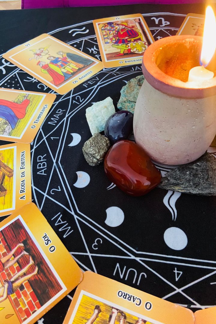 Mesa de tarot com vela e cristais