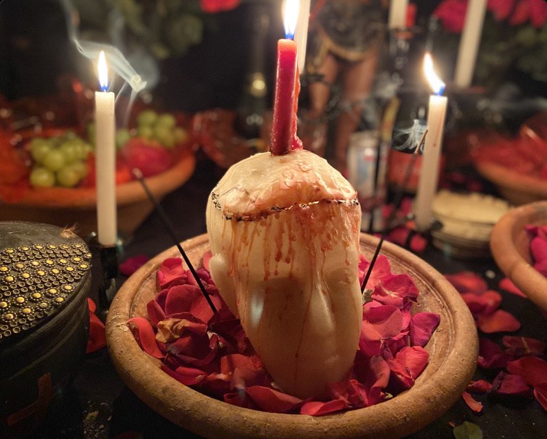 Cabeça de cera com vela vermelha